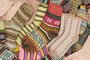 A pile of colorful, warm socks. Lots of different socks for the cold seasons. Clothing in the form of socks.
