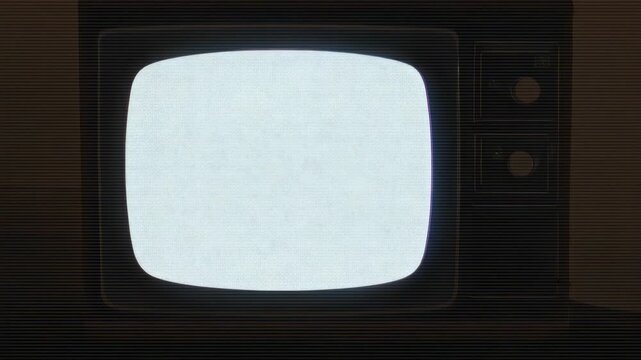 Showing CRT TV emitting static in dim room, showing faint band from interference with two knobs