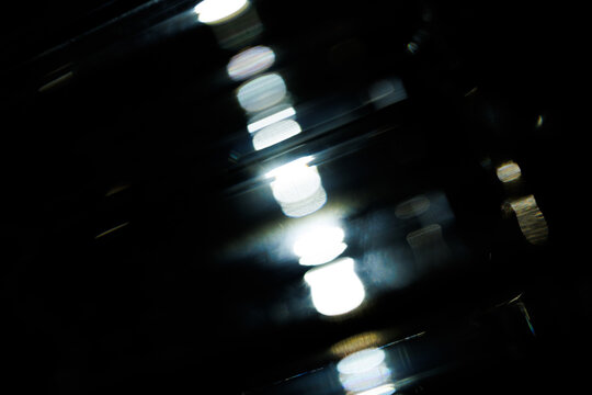 Lens Flare. Light over black background. Easy to add overlay or screen filter over photos. Abstract sun burst with digital lens flare background. Gleams rounded and hexagonal shapes.
