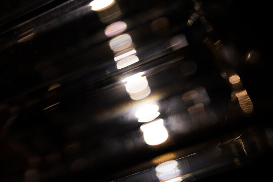 Lens Flare. Light over black background. Easy to add overlay or screen filter over photos. Abstract sun burst with digital lens flare background. Gleams rounded and hexagonal shapes.