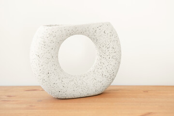 Ceramic vase on a wooden table in trending color of year 2026.