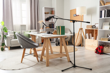 Interior of podcaster's studio with workplace, sofa and bookshelves