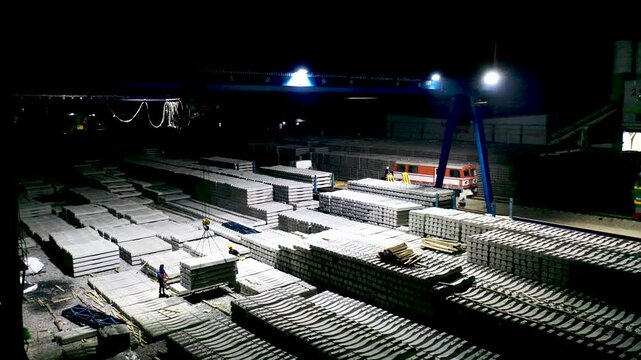 Industrial Construction Site at Night with Concrete Materials and Equipment