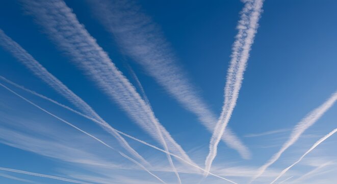The intricate patterns of contrails high in the sky.