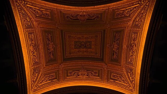 Tilting camera zooming out, revealing coffered ceiling panel at hall to show lit cornice