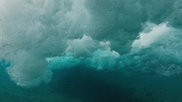 Teen boy surfer rides the wave in the ocean in the Maldives and does radical snap on the section
