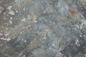 Naklejka premium water flowing over stone, creating a natural and abstract background