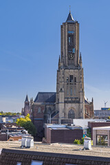 The tall tower of the Eusebius Church dominating the skyline of Arnhem, Netherlands, viewed from above over modern city buildings.