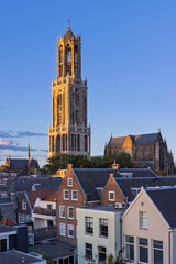 The iconic Dom Tower of Utrecht, the tallest church tower in the Netherlands, viewed over city rooftops during the golden hour.