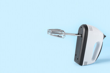 Electric mixer on blue background