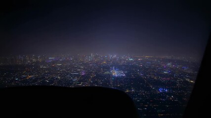 Approach starting plane descending, showing night city grid for landing with wing and window frame - Powered by Adobe