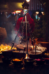 Hot kettles with cooking food on bonfire