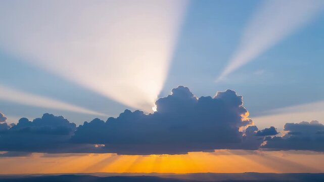 Blocking large cumulus cloud revealing golden horizon at sunset sun peeking behind creating rays