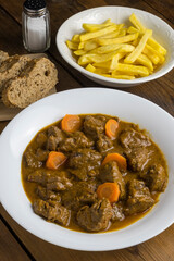 Carne en salsa y patatas fritas al estilo canario
