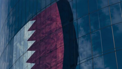 Panning camera showing curved glass tower facade in city, revealing maroon-white serrated motif