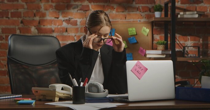 A young businesswoman sits dejectedly at her desk in the office - Powered by Adobe