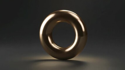 Animating polished golden torus rotating, revealing facets on gray studio floor with spotlight glow - Powered by Adobe