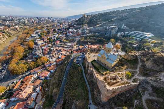 Aerial view of the Metekhi Church standing proudly on a cliff overlooking the Mtkvari River and the ancient Narikala Fortress, Tbilisi, Tbilisi, Georgia.