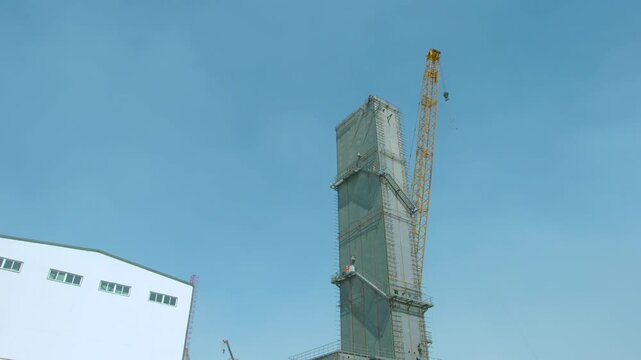 Large Construction Site with Tower Crane and Building Scaffolding