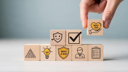 Hand placing final wooden block with happy face icon on tower of blocks representing business success and safety
