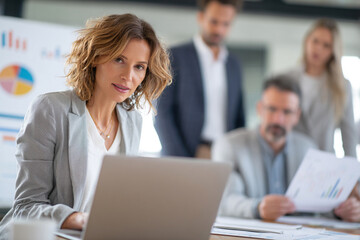 Confident businesswoman in a meeting room, focused expression.