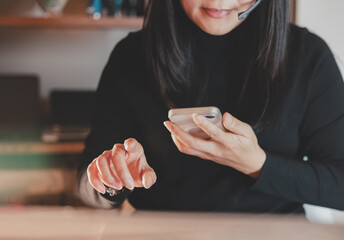 Close up of businesswoman using smartphone with headset, interacting with customer in online meeting or remote support. Ideal for service communication, teleworking, or digital consulting scenes.