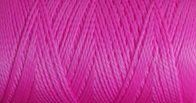Pink Thread Macro Seamless Loop. Extreme close-up of bright pink sewing thread strands gently moving and catching light in a hypnotic repeating pattern.	