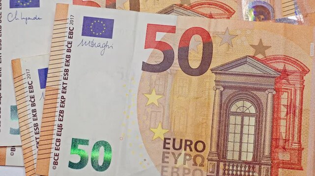 Euro banknotes falling onto a table in a scattered arrangement, representing cash flow, wealth, abundance, financial prosperity, and money movement concepts.