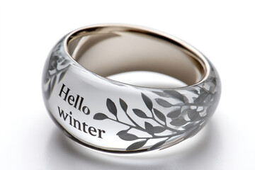 Elegant glass ring sculpture engraved with hello winter message on reflective background for seasonal decor