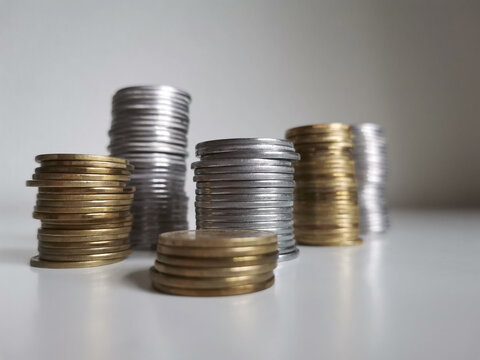 Copper and silver coin piles on white background