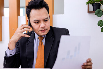 Dynamic Entrepreneur Analyzes Financial Data While on an Important Call