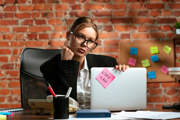 Young Woman in Glasses Holding Laptop with Note