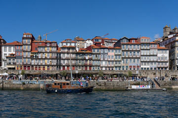Colorful buildings line the Douro River in Porto, Portugal, on a sunny day