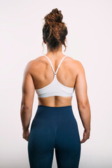 Obraz premium Athletic woman showing strong back muscles in sportswear