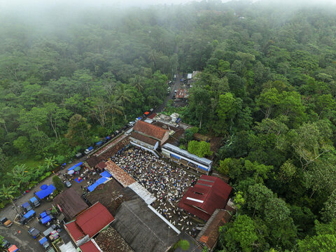 Aerial view of dense, green forest meets the bustling activity of the Kaligesing goat market, a vibrant contrast between nature and commerce., Purworejo, Central Java, Indonesia.