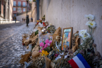 Memorial with flowers and a painting on a city street