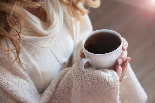 Girl drinking a cup of coffee, close-up 