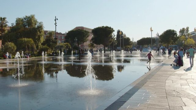4K French Riviera Nice Promenade du Paillon water mirror with young girl playing in the distance slow motion