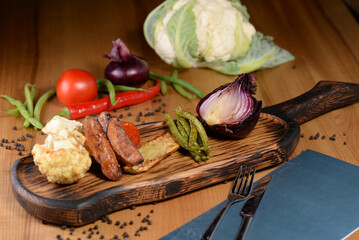 Grilled roasted vegetables on a wooden board on a table with food decor