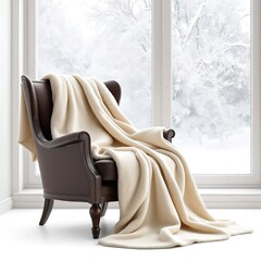 A cozy scene featuring a brown chair draped with a cream blanket near a window in a winter setting