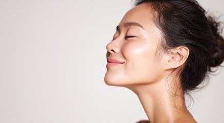Woman's profile with eyes closed against a light background.