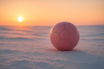 Pink soccer ball on snowy ground with soft sunset light, minimalist winter sports concept