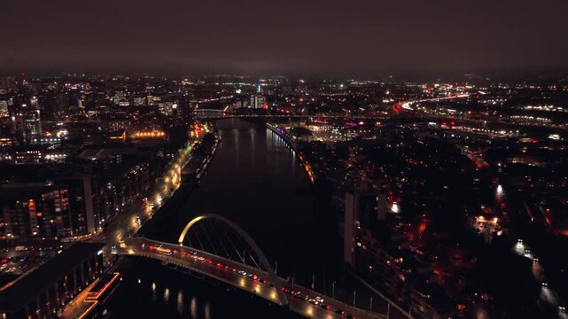 Glasgow Scotland: 26th Nov 2025: The River Clyde in Glasgow at night. Clyde Arc bridge cross over the water, and city lights reflect on the river. Cars move along the streets