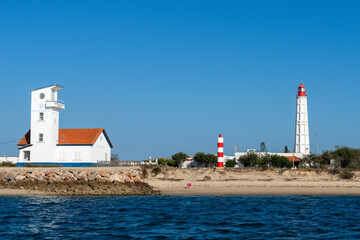 Scenic view of lighthouses and buildings on a sunny day by the sea
