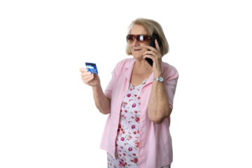 Senior woman paying online with credit card while talking on her smartphone