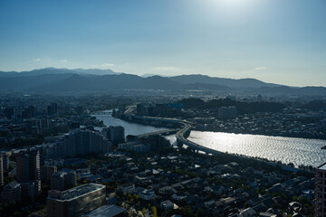 Aerial view of a city with a river and mountains in the background