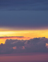 Vibrant sunset sky spreading warm, magical hues across drifting afternoon clouds