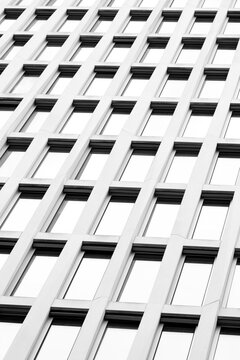 Architecture facade built on pattern and repetition supported by geometry, glass, reflection, structure, symmetry and abstract pattern to present a minimal balanced commercial visual frame