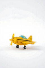 Yellow toy airplane against a white background isolated and conceptual