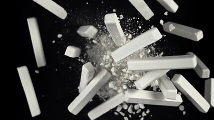 School chalk flies up and falls down on a black background. Filmed on a high-speed camera at 1000 fps. High quality FullHD footage